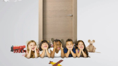 Primo piano di un gruppo di bambini felici, con alle loro spalle una porta Bertolotto