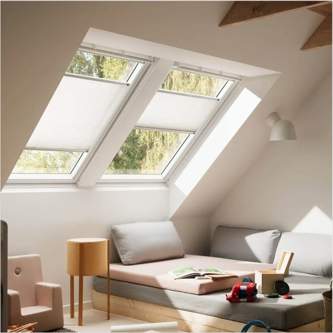 Foto di due finestre Velux con tende plissettate.