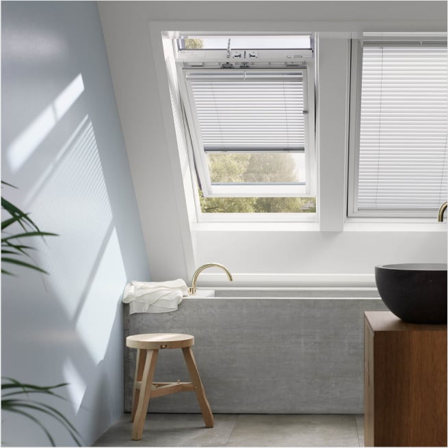 Foto di due finestre Velux con tende alla veneziana.